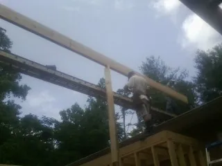 Carpenter setting a ridge beam over a new addition frame — Ice Dam Removal by Roofing Brothers in Intervale