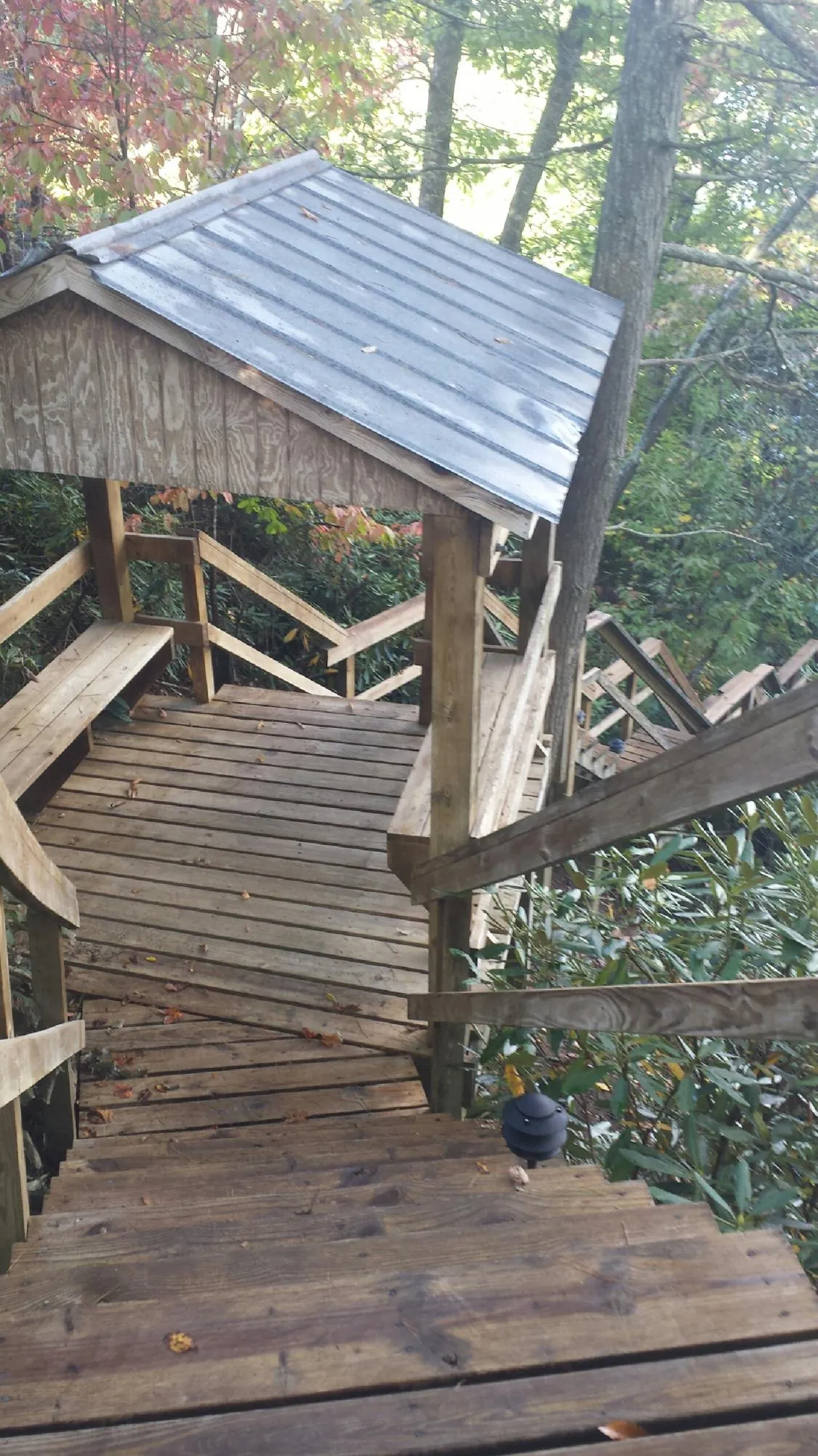 Metal roofed shelter over wooden steps on a wooded walkway — Skylight Repair & Installation work by our crew in Intervale