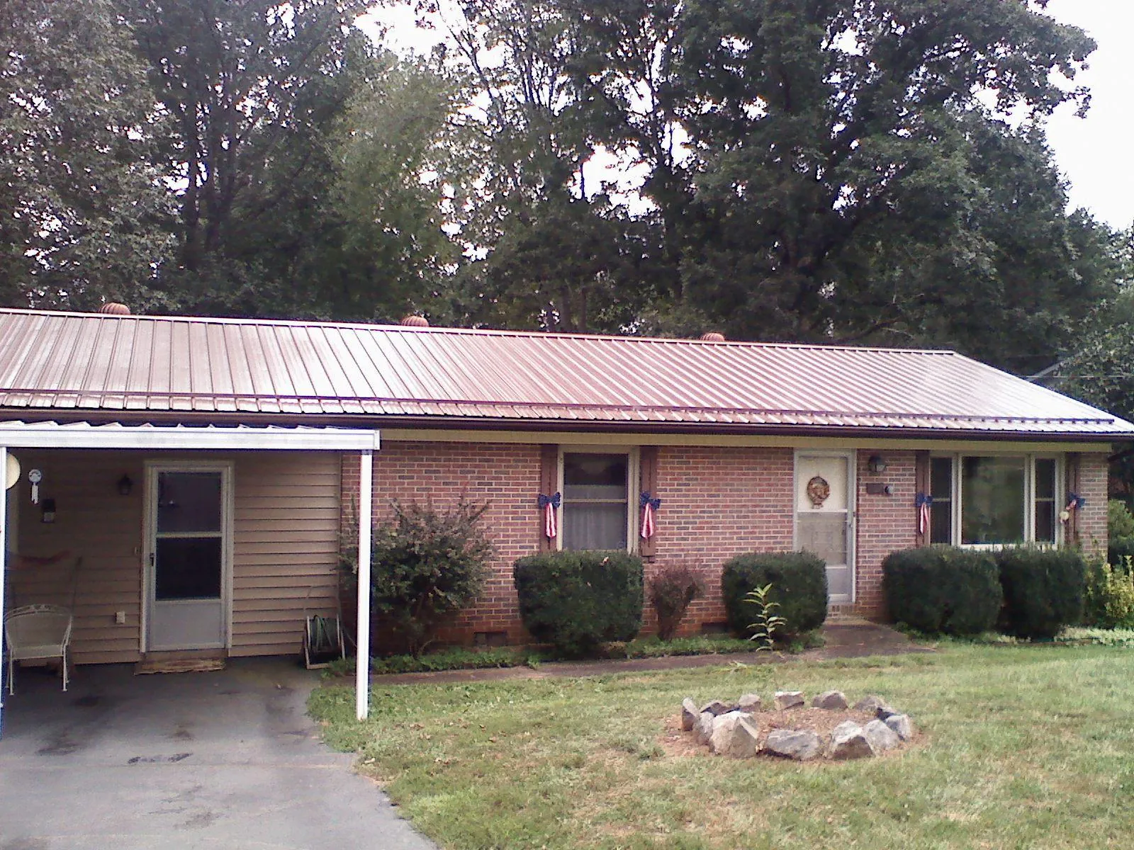 Bronze metal roof and carport on a brick ranch home — Roof Repair work by our crew in Intervale